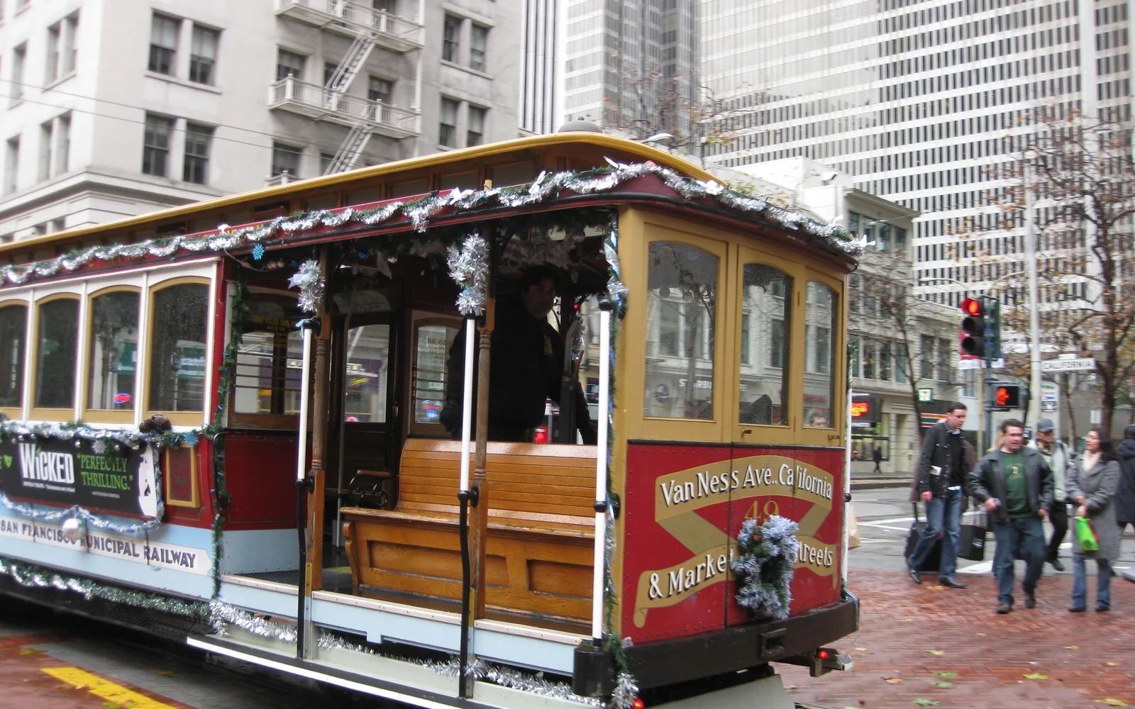 A San Francisco cable car on a steep hill street, showing the distinctive vehicle and urban infrastructure of the city